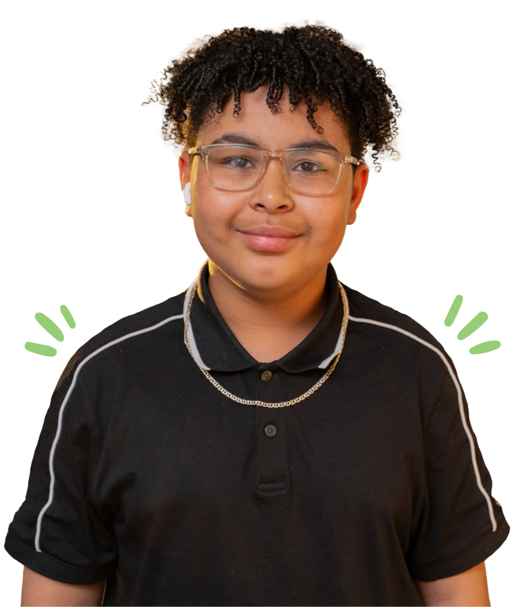 Smiling teenager with glasses and earbuds, wearing a black polo shirt and a chain necklace.