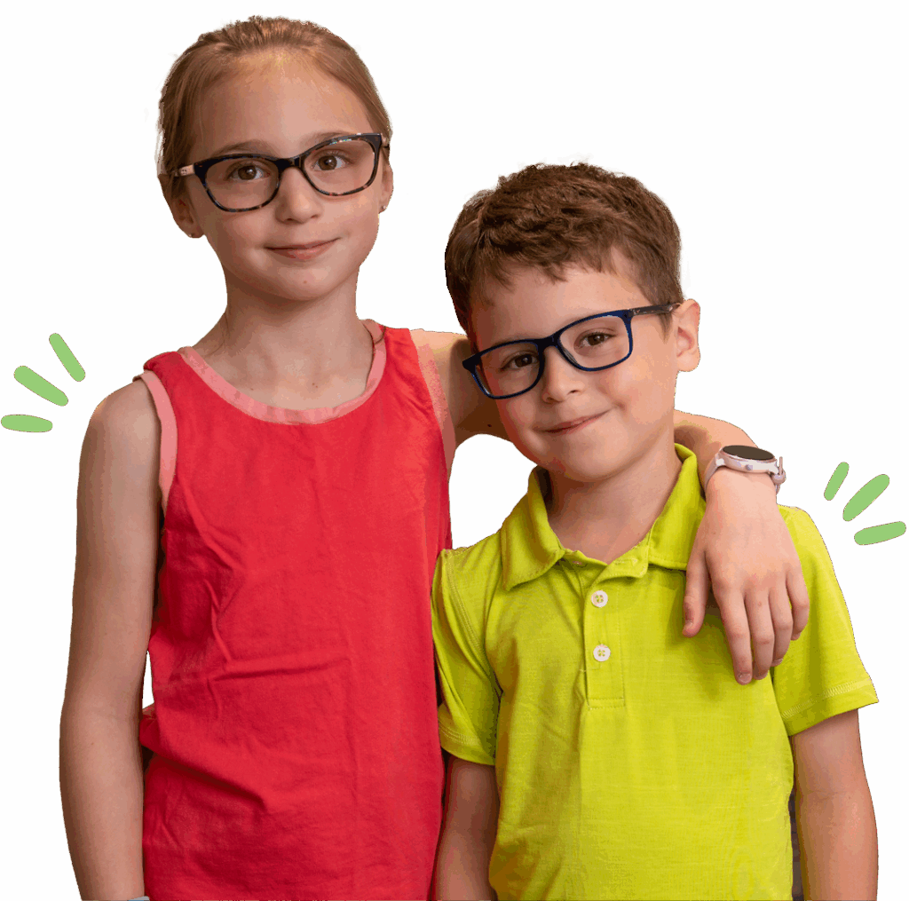 Two kids with glasses, one in a pink dress and the other in a yellow shirt, smiling and posing together.